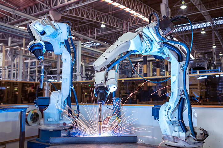 Two industrial robotic manipulators at a plant.